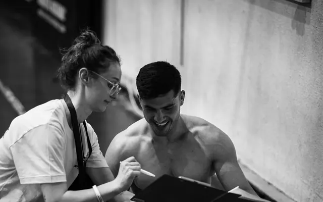 Eine Frau und ein Mann besprechen das Training im Fitnessraum