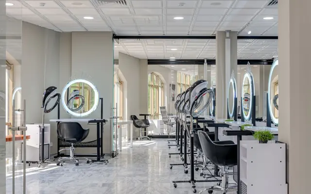 Ein heller Salon mit großen Spiegeln und Sesseln